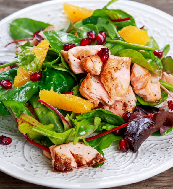 Fresh Salmon Salad with vegetables, pomegranate and orange