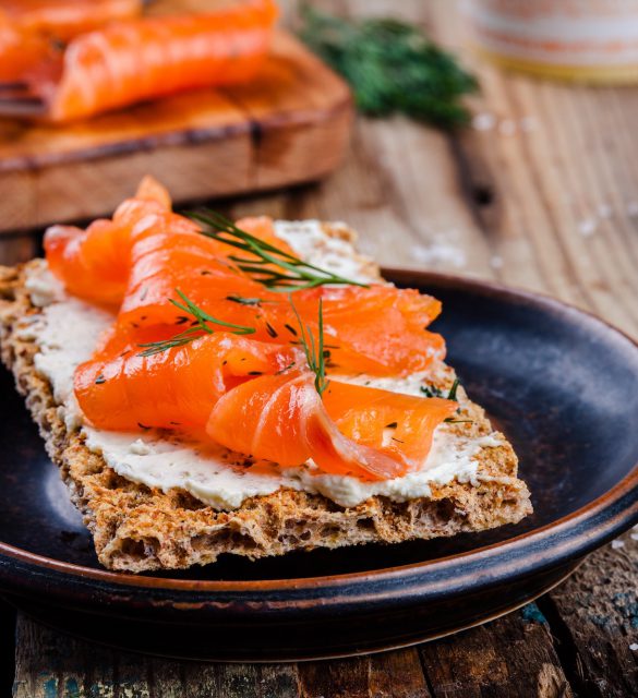 Toast with smoked salmon on wooden table