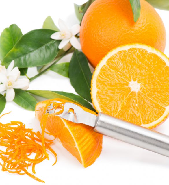 Orange fruit with leaves and blossom, orange zest with zester isolated on a white background.